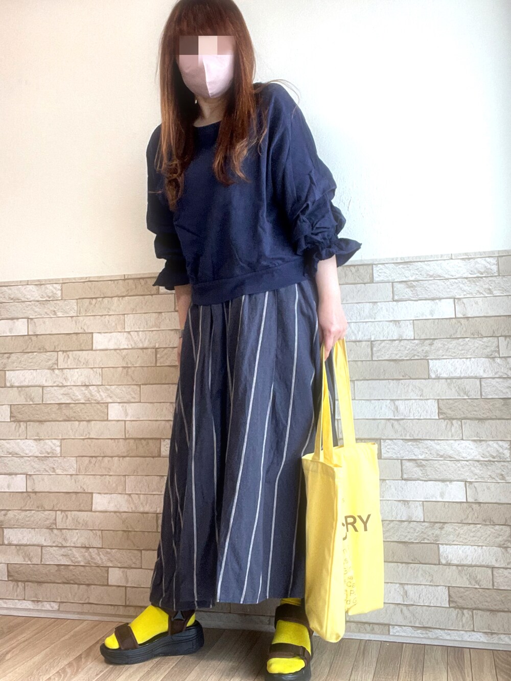 ブルー系のTシャツ/カットソー、イエロー系のトートバッグ、ブラウン系のサンダルを着用したレディースの春コーディネートの4枚目の写真