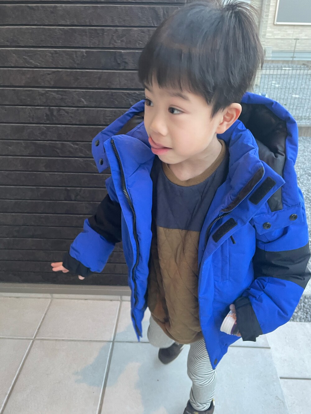 ホワイト系のパンツ、ブラウン系のスニーカー、ブルー系のダウンジャケット/コートを着用したキッズの冬コーディネートの2枚目の写真
