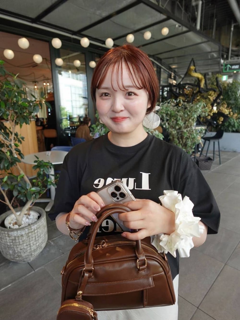 ホワイト系のスカート、ブラック系のTシャツ/カットソーを着用したレディースの春コーディネートの2枚目の写真