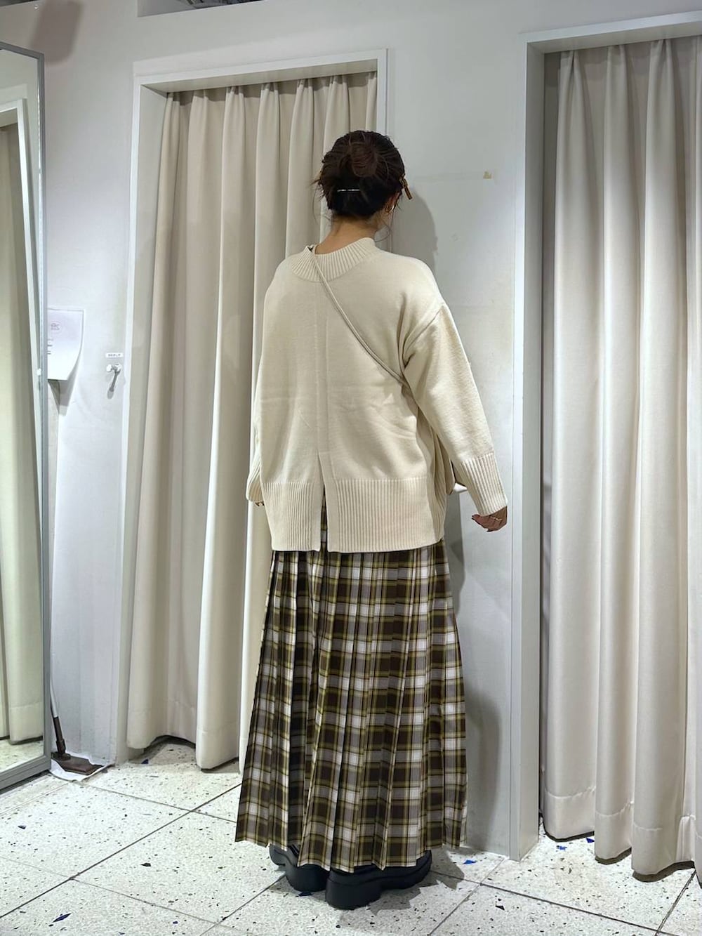 ホワイト系のニット/セーター、ブラック系のブーツ、ベージュ系のスカートを着用したレディースの冬コーディネートの2枚目の写真