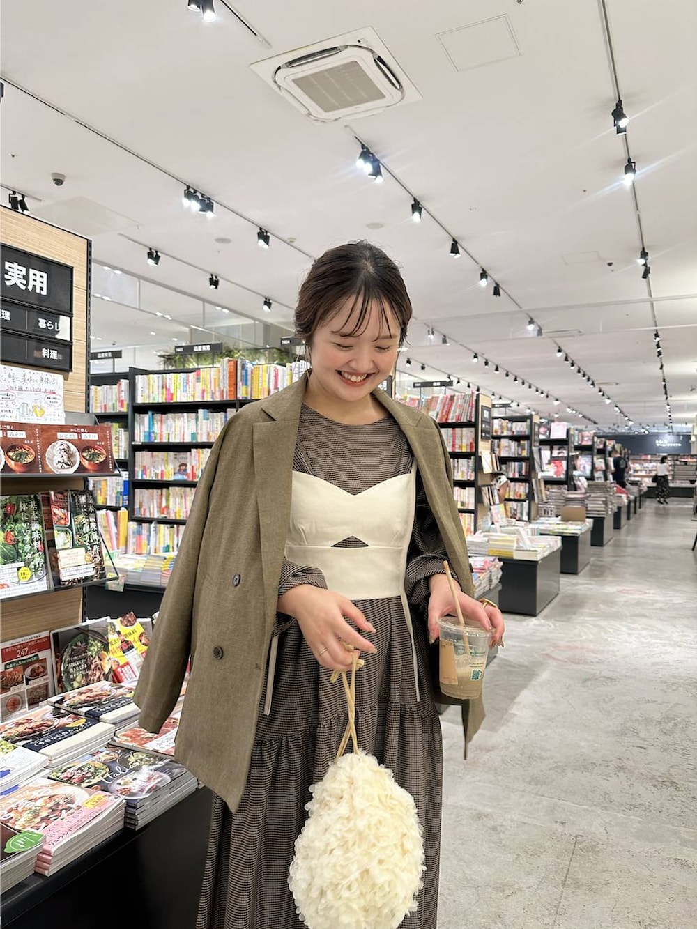 ホワイト系のハンドバッグを着用したレディースの秋コーディネートの2枚目の写真