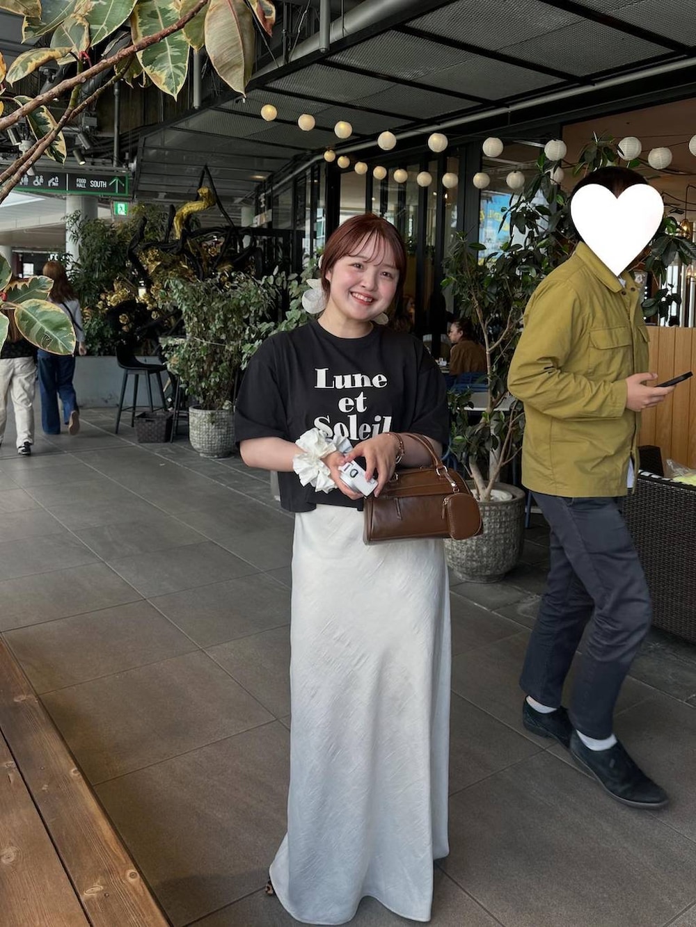 ホワイト系のスカート、ブラック系のTシャツ/カットソーを着用したレディースの春コーディネートの4枚目の写真