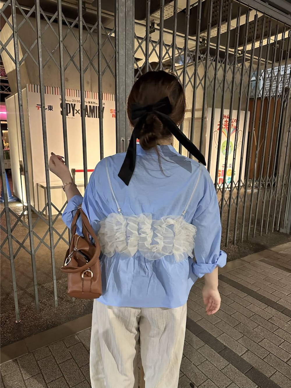 ブラウン系のボストンバッグ、ブルー系のシャツ/ブラウスを着用したレディースの秋コーディネートの2枚目の写真