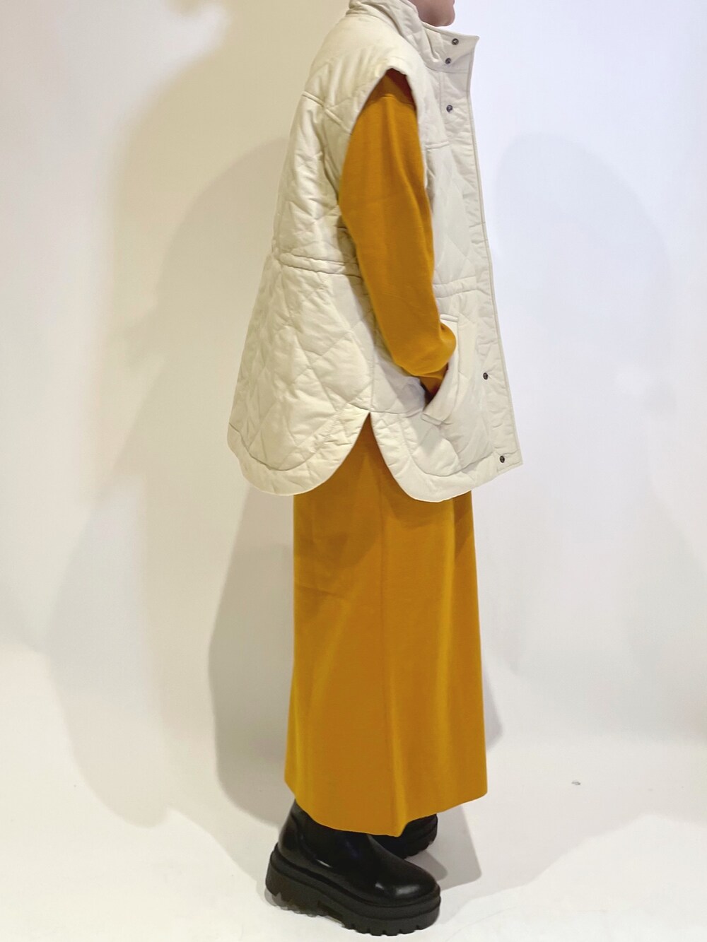 イエロー系のワンピース、ホワイト系のジャケット/アウターを着用したレディースの秋コーディネートの2枚目の写真