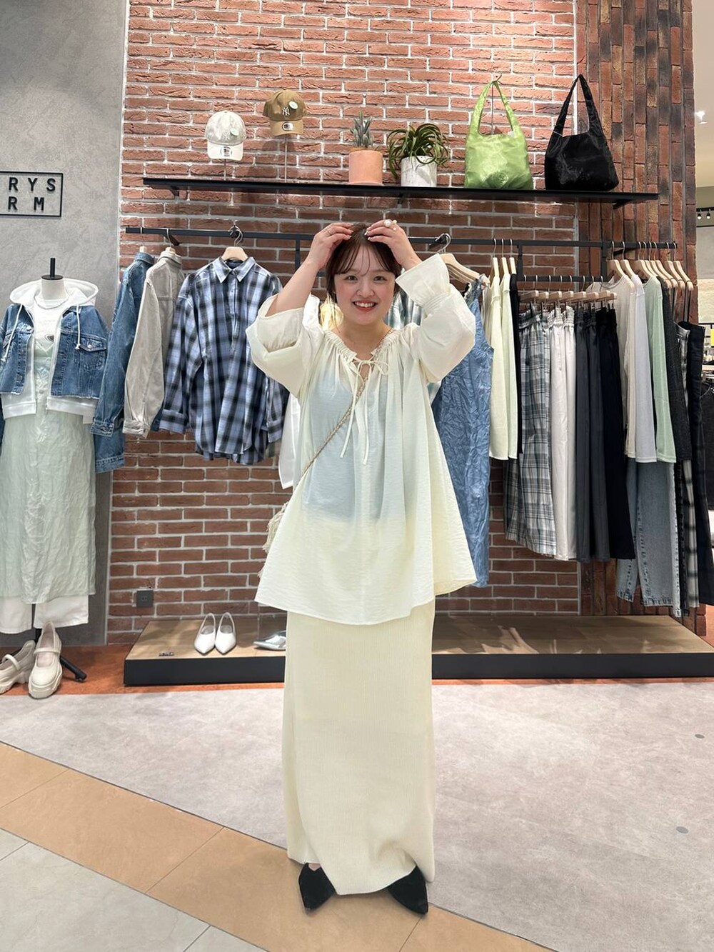 ホワイト系のスカート、ベージュ系のシャツ/ブラウスを着用したレディースの春コーディネートの2枚目の写真