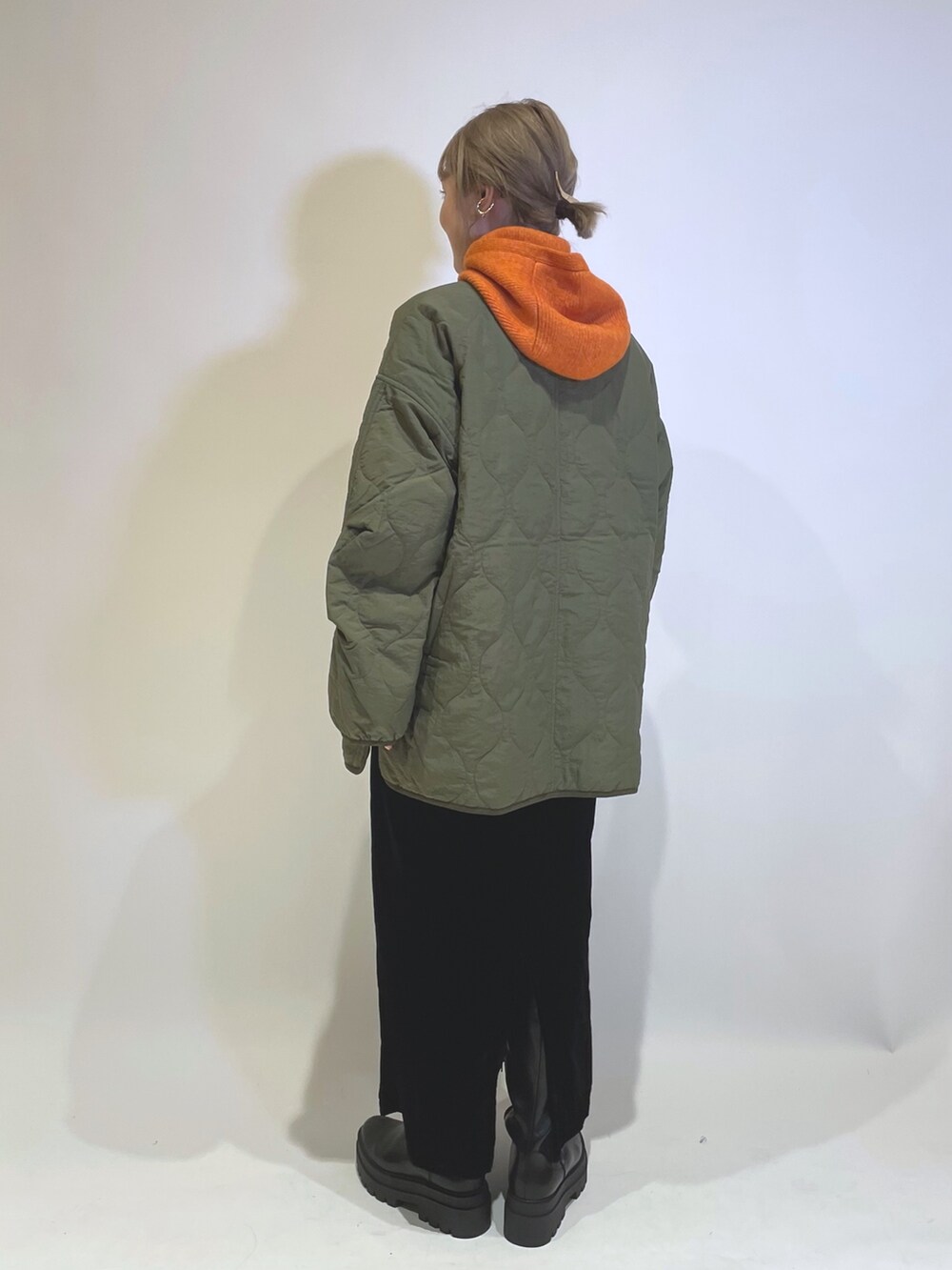 グリーン系のブルゾン、ブラック系のワンピース/ドレス、オレンジ系のファッション雑貨を着用したレディースの秋コーディネートの3枚目の写真