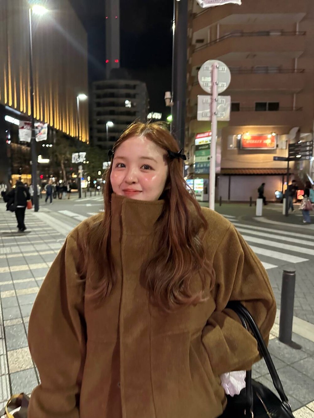 ブラウン系のスカート、ブラック系のボストンバッグ、ブラウン系のブルゾンを着用したレディースの秋コーディネートの3枚目の写真