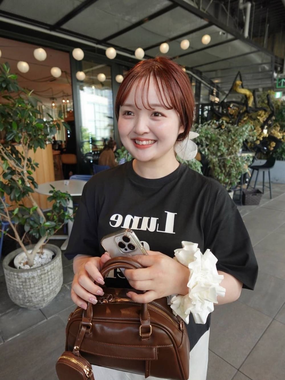 ホワイト系のスカート、ブラック系のTシャツ/カットソーを着用したレディースの春コーディネートの3枚目の写真