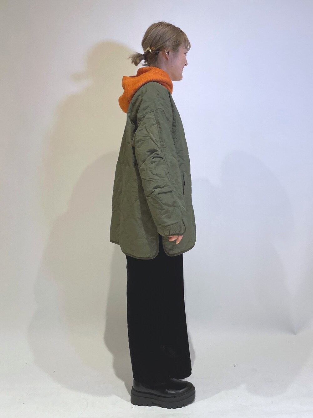 グリーン系のブルゾン、ブラック系のワンピース/ドレス、オレンジ系のファッション雑貨を着用したレディースの秋コーディネートの2枚目の写真