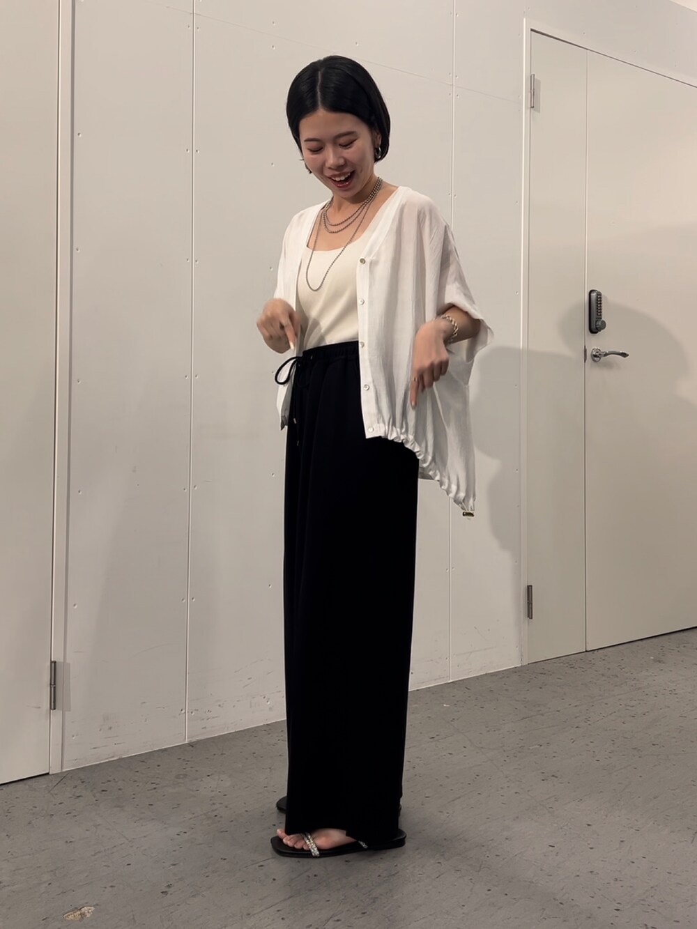 ホワイト系のシャツ/ブラウス、ブラック系のその他パンツ、ブラック系のサンダルを着用したレディースの夏コーディネートの3枚目の写真