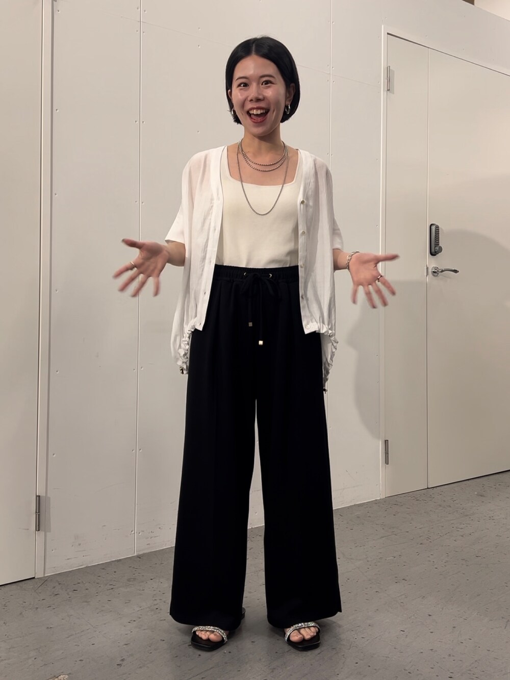 ホワイト系のシャツ/ブラウス、ブラック系のその他パンツ、ブラック系のサンダルを着用したレディースの夏コーディネートの2枚目の写真