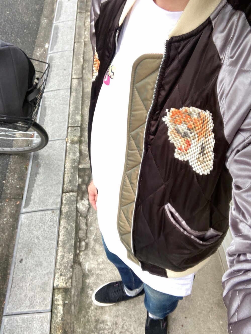 ブラック系のスカジャン、ホワイト系のTシャツ/カットソー、ブルー系のデニムパンツを着用したメンズの春コーディネートの2枚目の写真