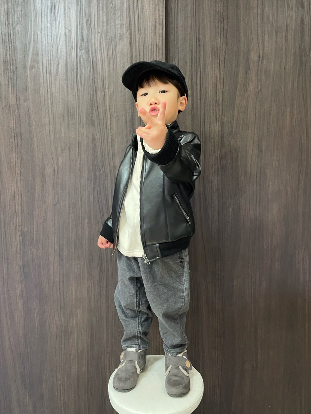 ホワイト系のスウェット、ブラック系のデニムパンツ、グレー系のブーツを着用したキッズの冬コーディネートの2枚目の写真