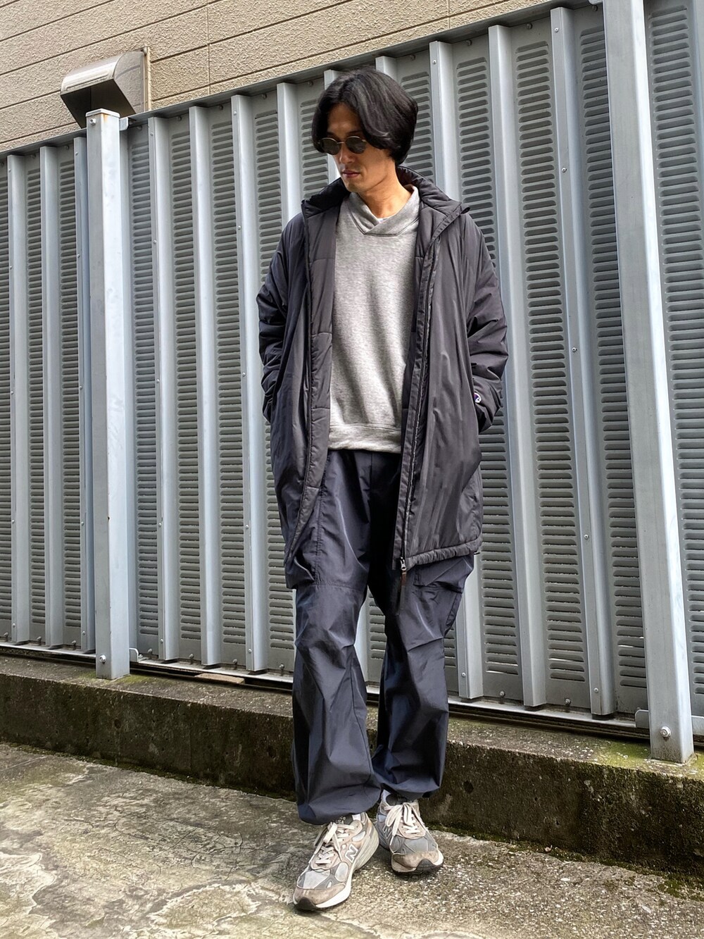 グレー系のスウェット、ブラック系のブルゾン、ブルー系のその他パンツを着用したメンズの秋コーディネートの2枚目の写真