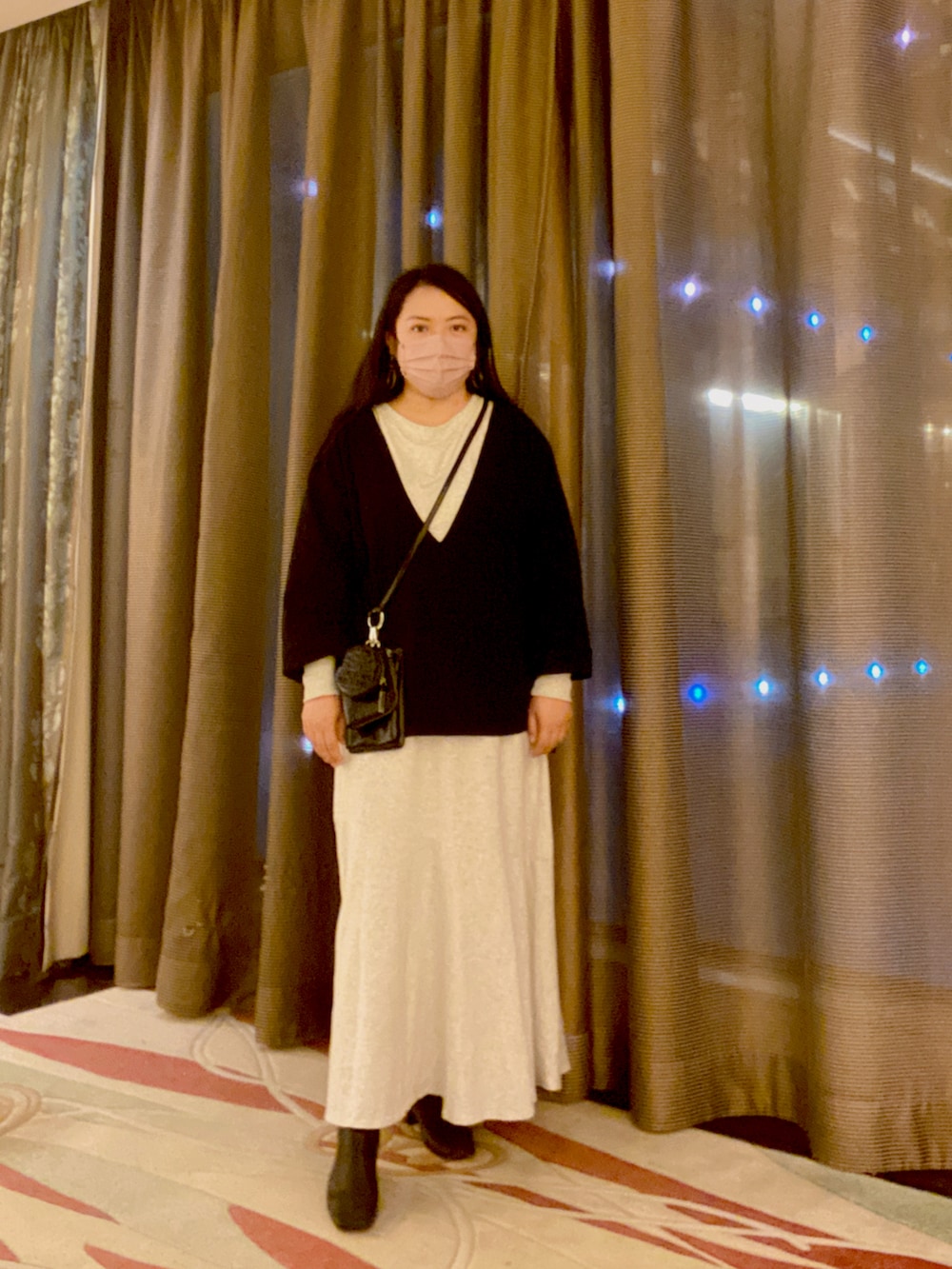 ベージュ系のその他アウター、ホワイト系のワンピース、ブラック系のショルダーバッグを着用したレディースの冬コーディネートの2枚目の写真