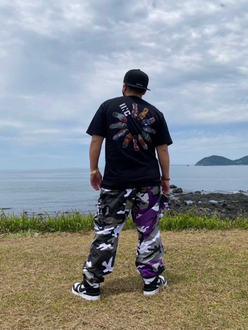 ブラック系のTシャツ/カットソー、グレー系のカーゴパンツを着用したメンズの春コーディネートの2枚目の写真