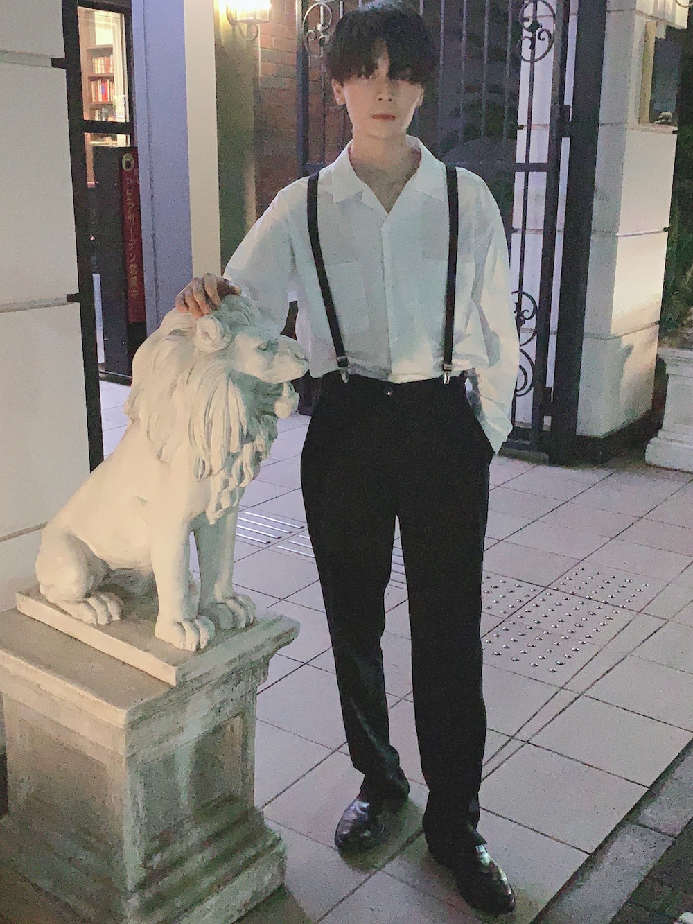 ホワイト系のポロシャツ、ブラック系のスラックス、ブラック系のサスペンダーを着用したメンズの春コーディネートの3枚目の写真