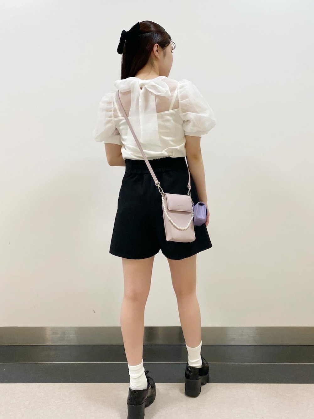 ホワイト系のTシャツ/カットソー、パープル系のショルダーバッグ、ブラック系のその他パンツを着用したレディースの夏コーディネートの2枚目の写真
