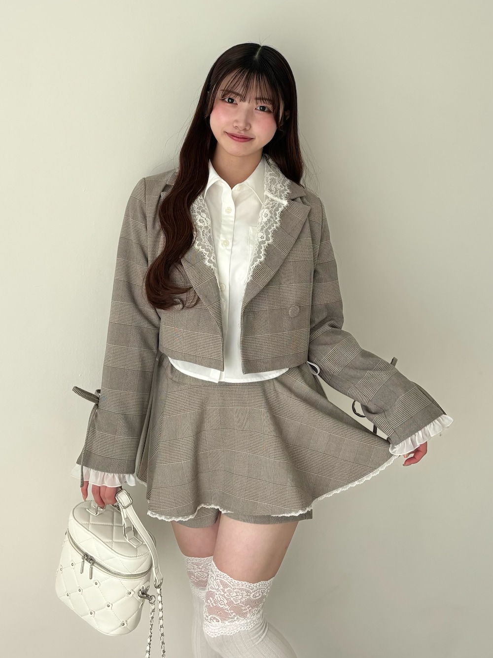 ホワイト系のシャツ/ブラウス、ブラウン系のテーラードジャケット、ブラウン系のスカートを着用したレディースの冬コーディネートの4枚目の写真