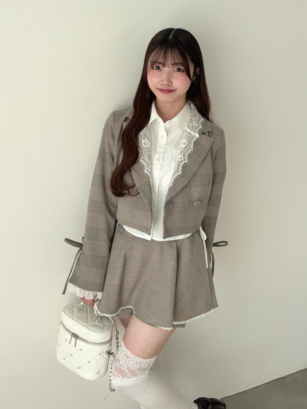 ホワイト系のシャツ/ブラウス、ブラウン系のテーラードジャケット、ブラウン系のスカートを着用したレディースの冬コーディネートの3枚目の写真