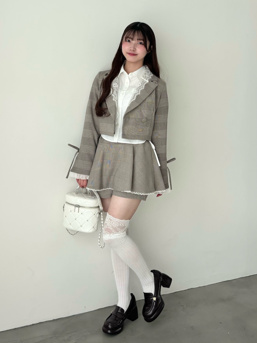 ホワイト系のシャツ/ブラウス、ブラウン系のテーラードジャケット、ブラウン系のスカートを着用したレディースの冬コーディネートの2枚目の写真