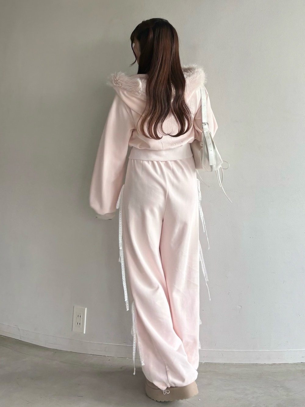 ピンク系のTシャツ/カットソー、ホワイト系のショルダーバッグ、ピンク系のスウェットパンツを着用したレディースの秋コーディネートの2枚目の写真