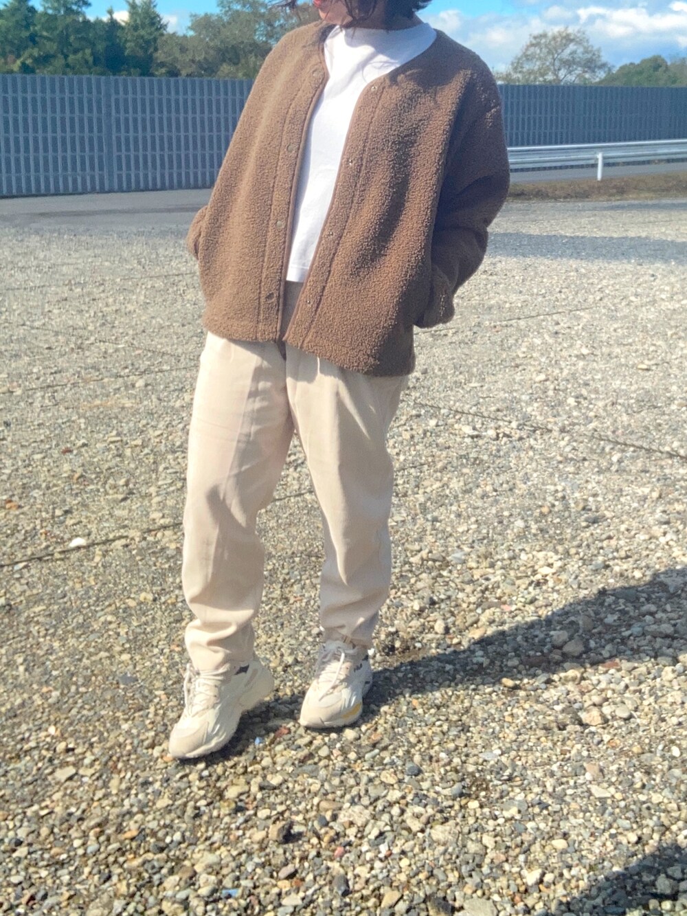 ブラウン系のトップス、ホワイト系のTシャツ/カットソー、ホワイト系のパンツを着用したレディースの秋コーディネートの2枚目の写真