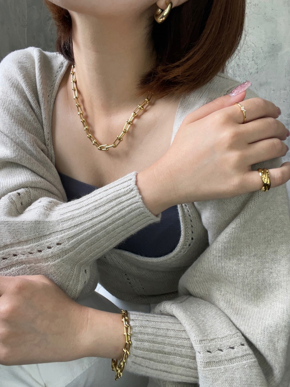 ホワイト系のトップス、ゴールド系のピアス（両耳用）、ゴールド系のネックレスを着用したレディースの秋コーディネートの3枚目の写真