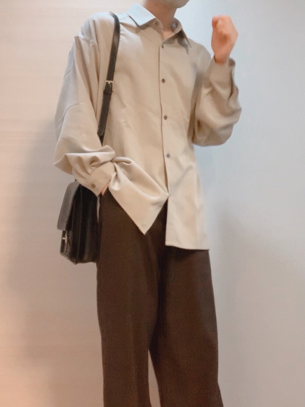 ブラウン系のスラックス、ベージュ系のシャツ/ブラウス、ブラック系のショルダーバッグを着用したメンズの秋コーディネートの3枚目の写真