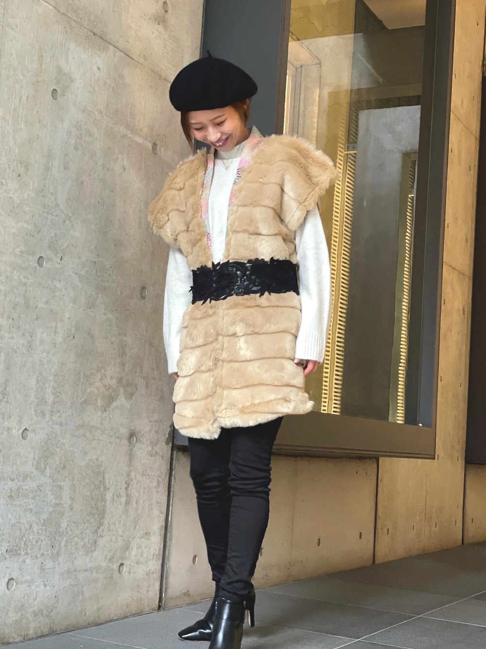 ブラック系のニット/セーター、ブルー系のデニムパンツ、ホワイト系のスニーカーを着用したレディースの冬コーディネートの5枚目の写真