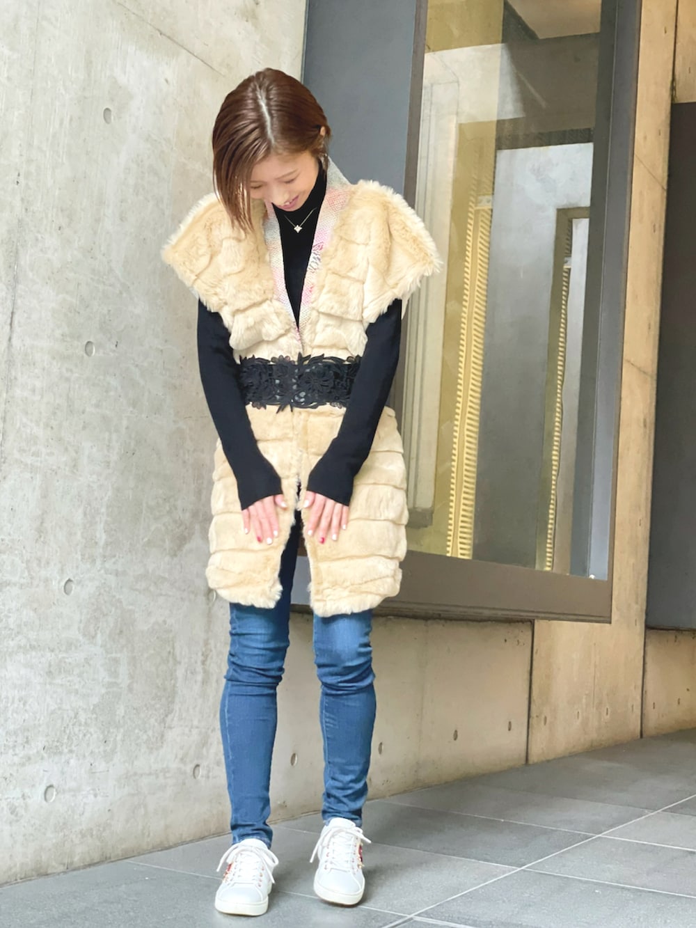ブラック系のニット/セーター、ブルー系のデニムパンツ、ホワイト系のスニーカーを着用したレディースの冬コーディネートの3枚目の写真