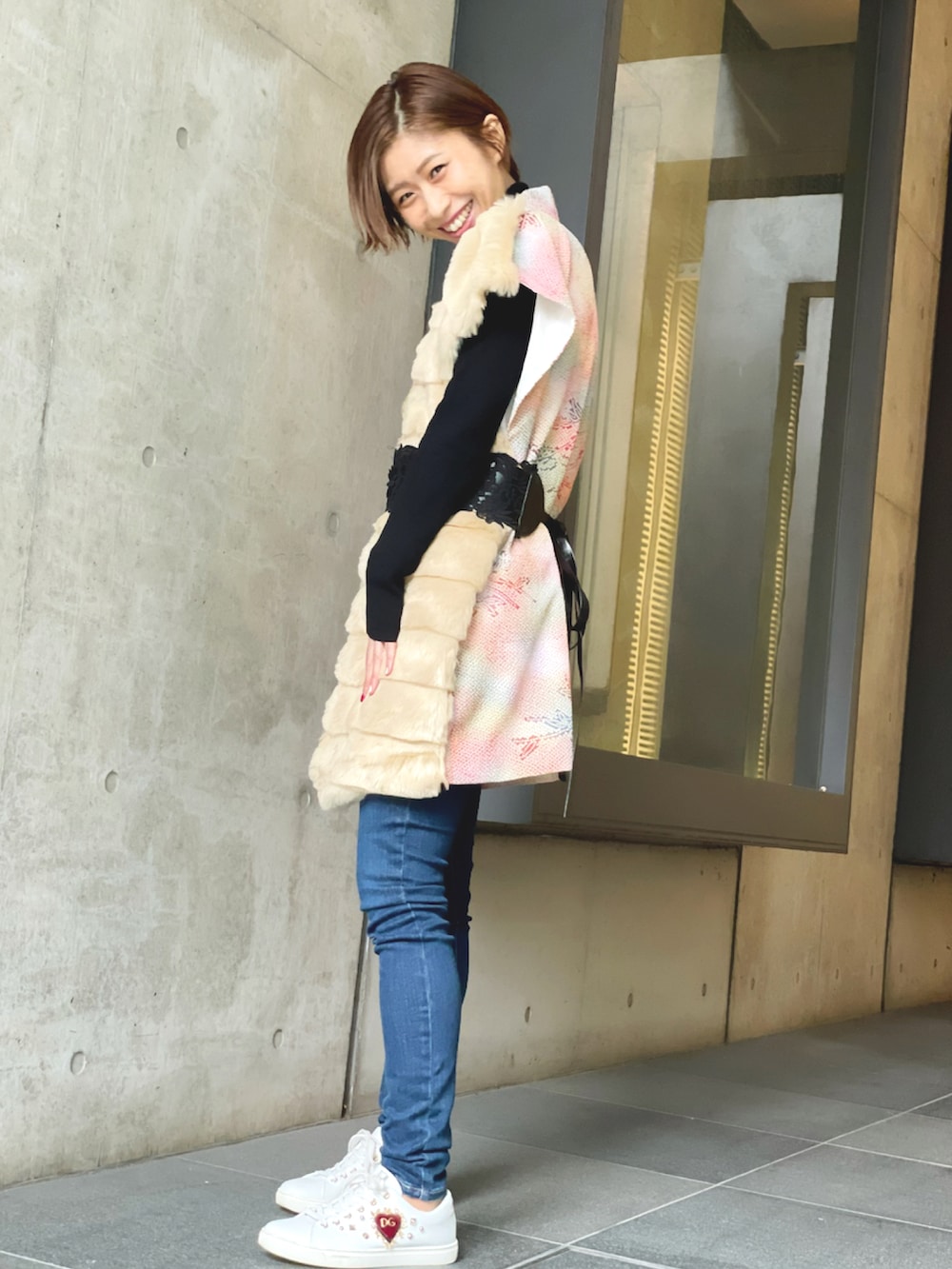 ブラック系のニット/セーター、ブルー系のデニムパンツ、ホワイト系のスニーカーを着用したレディースの冬コーディネートの2枚目の写真