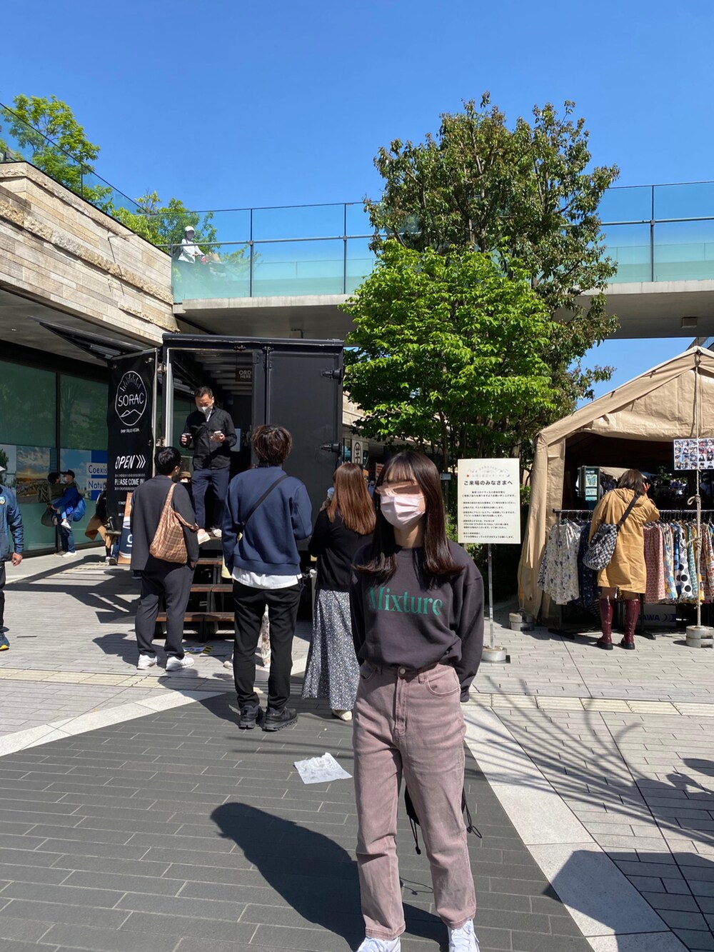 ピンク系のデニムパンツ、ホワイト系のスニーカー、グレー系のスウェットを着用したレディースの春コーディネートの2枚目の写真