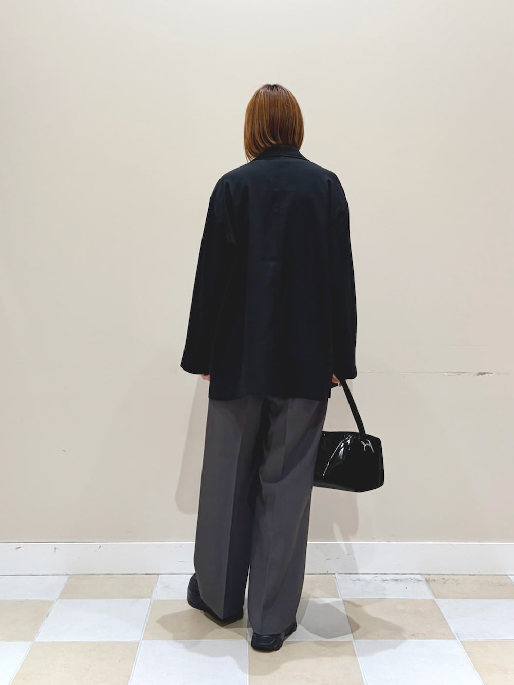 ブラック系のその他アウター、グレー系のその他パンツ、グレー系のニット/セーターを着用したレディースの春コーディネートの3枚目の写真