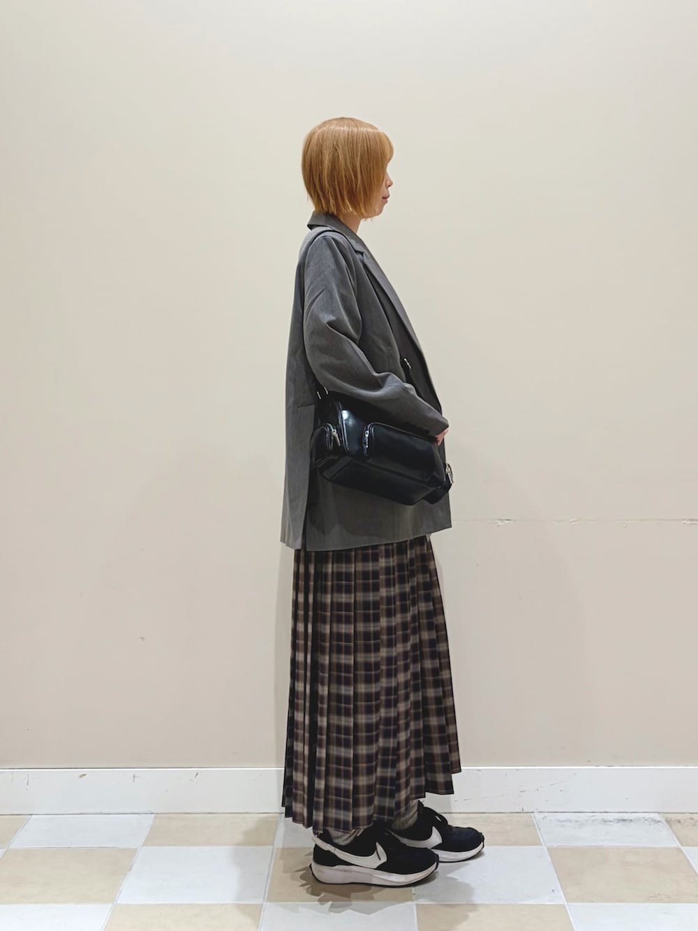 ブルー系のスカート、グレー系のテーラードジャケットを着用したレディースの春コーディネートの2枚目の写真