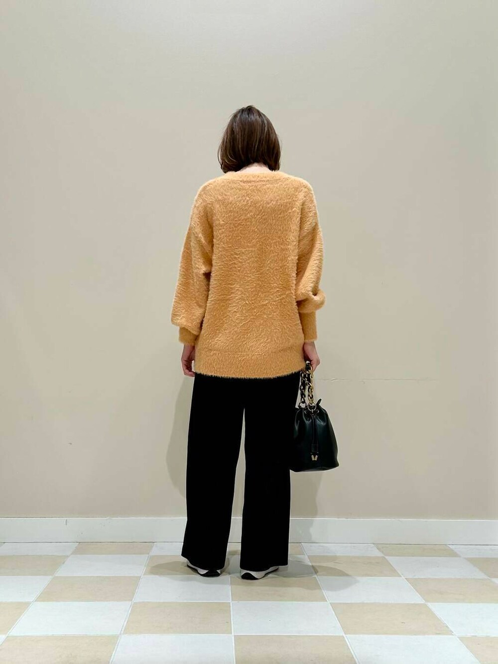 ブラック系のその他パンツ、ブラック系のショルダーバッグ、オレンジ系のニット/セーターを着用したレディースの冬コーディネートの3枚目の写真