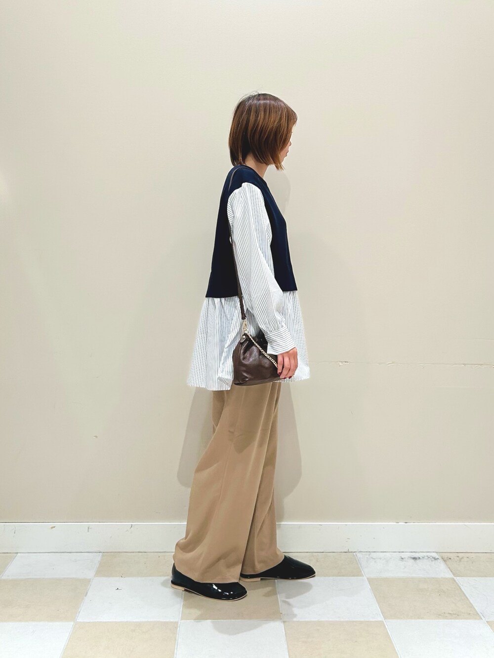 ブルー系のニット/セーター、ベージュ系のその他パンツ、ブラウン系のショルダーバッグを着用したレディースの秋コーディネートの2枚目の写真