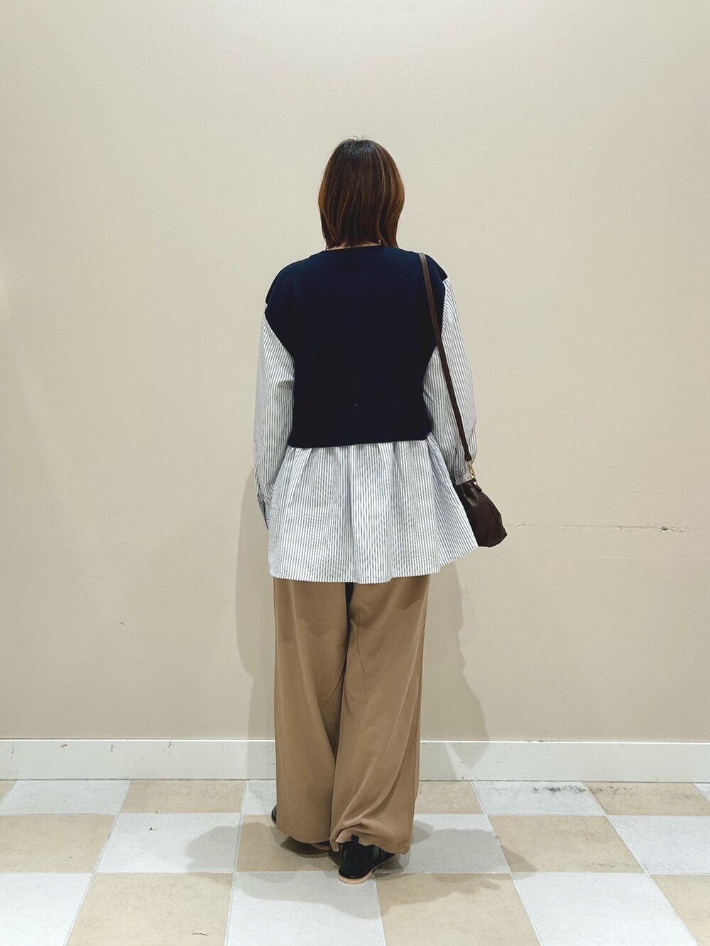 ブルー系のニット/セーター、ベージュ系のその他パンツ、ブラウン系のショルダーバッグを着用したレディースの秋コーディネートの3枚目の写真