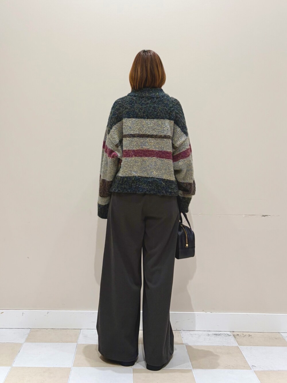 ブラック系のニット/セーター、ブラック系のその他パンツ、ブラウン系のブーツを着用したレディースの秋コーディネートの3枚目の写真