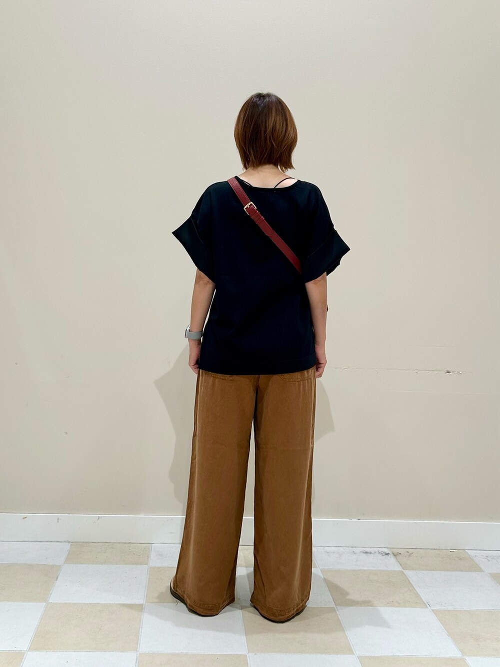 ブラック系のニット/セーター、ブラウン系のその他パンツ、レッド系のショルダーバッグを着用したレディースの秋コーディネートの3枚目の写真