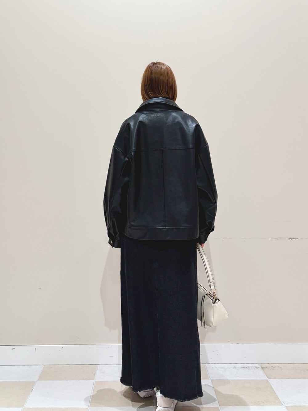 パープル系のニット/セーター、ブラック系のブルゾン、ブラック系のスカートを着用したレディースの冬コーディネートの3枚目の写真