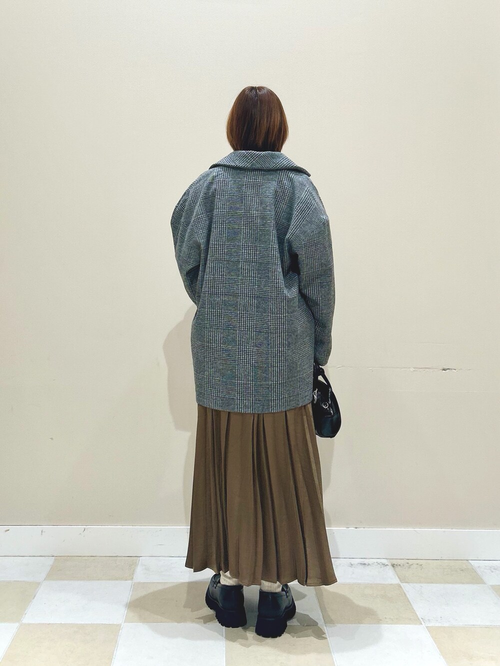 ホワイト系のスウェット、グリーン系のノーカラーコート、ブラウン系のスカートを着用したレディースの秋コーディネートの3枚目の写真