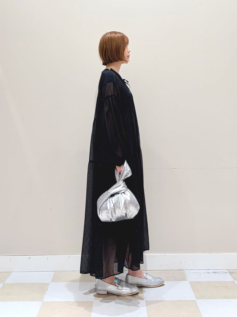 ブラック系のワンピース、シルバー系のハンドバッグを着用したレディースの冬コーディネートの2枚目の写真
