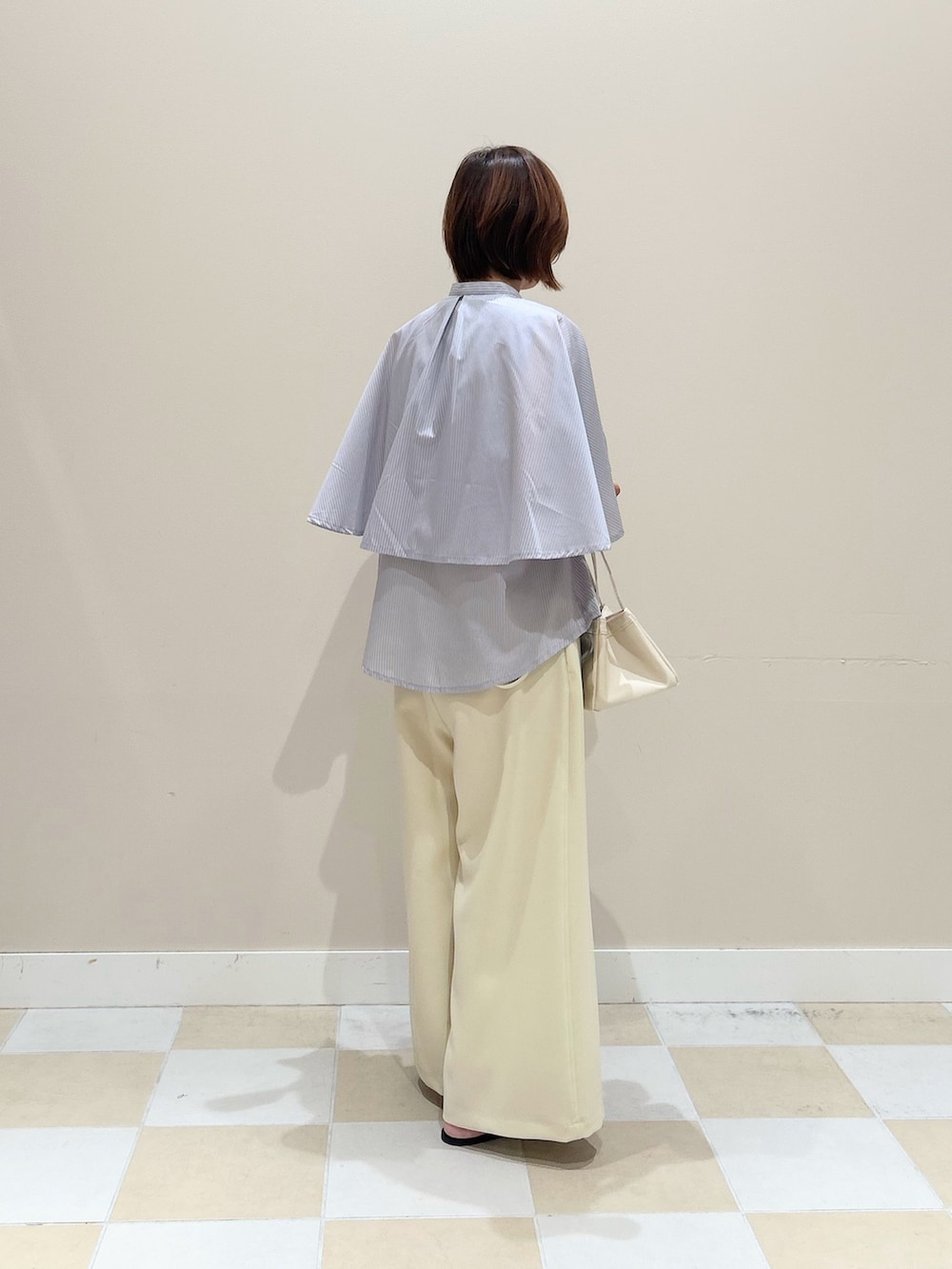 ブルー系のシャツ/ブラウス、ホワイト系のハンドバッグを着用したレディースの夏コーディネートの3枚目の写真