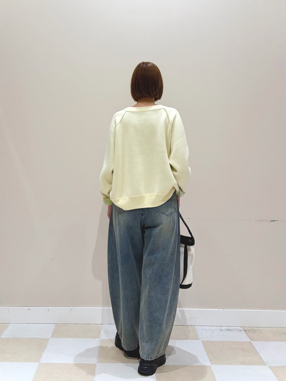 ホワイト系のニット/セーター、ブルー系のデニムパンツを着用したレディースの冬コーディネートの3枚目の写真