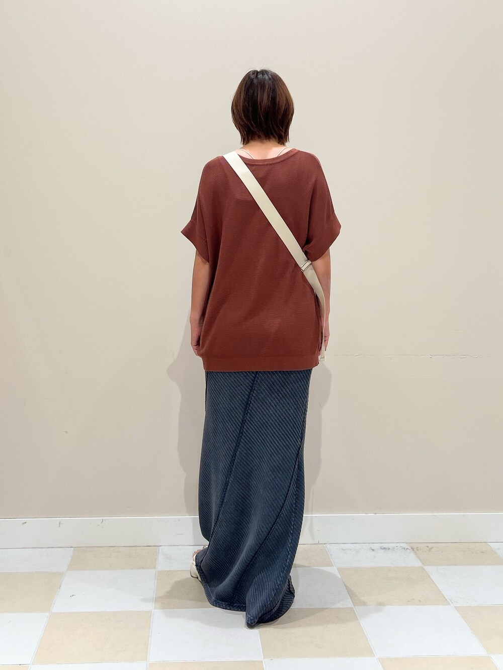 ホワイト系のショルダーバッグ、レッド系のニット/セーター、ブルー系のスカートを着用したレディースの夏コーディネートの3枚目の写真