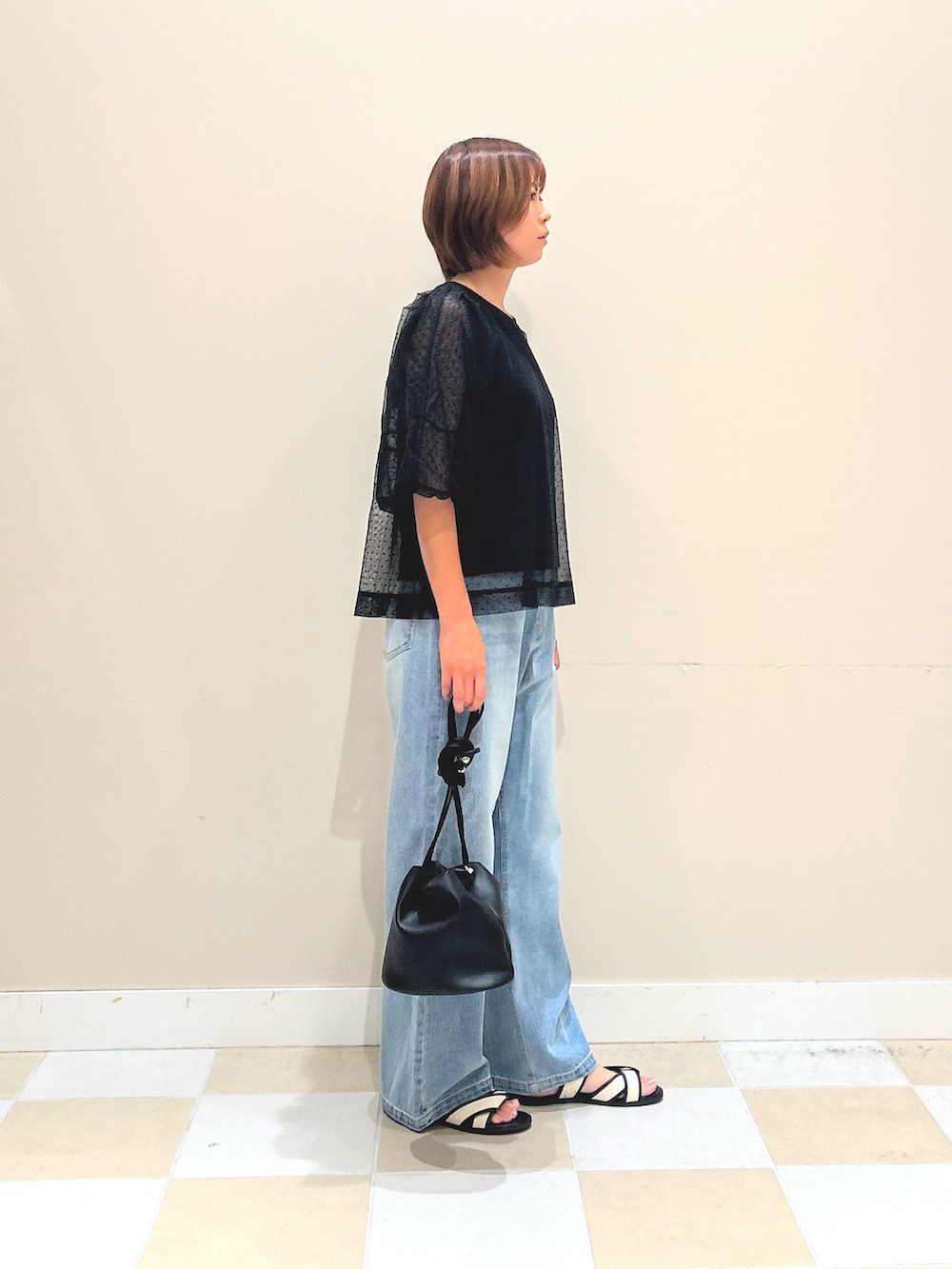 ブラック系のTシャツ/カットソー、ブルー系のデニムパンツ、ブラック系のショルダーバッグを着用したレディースの夏コーディネートの2枚目の写真