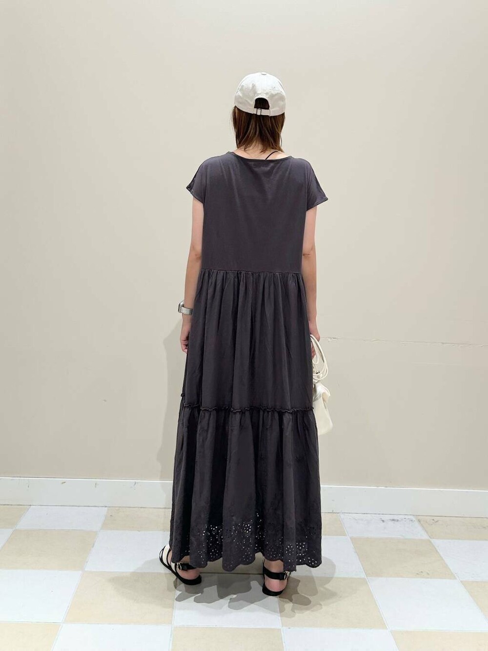 ホワイト系のショルダーバッグ、グレー系のワンピース、シルバー系のネックレスを着用したレディースの夏コーディネートの3枚目の写真