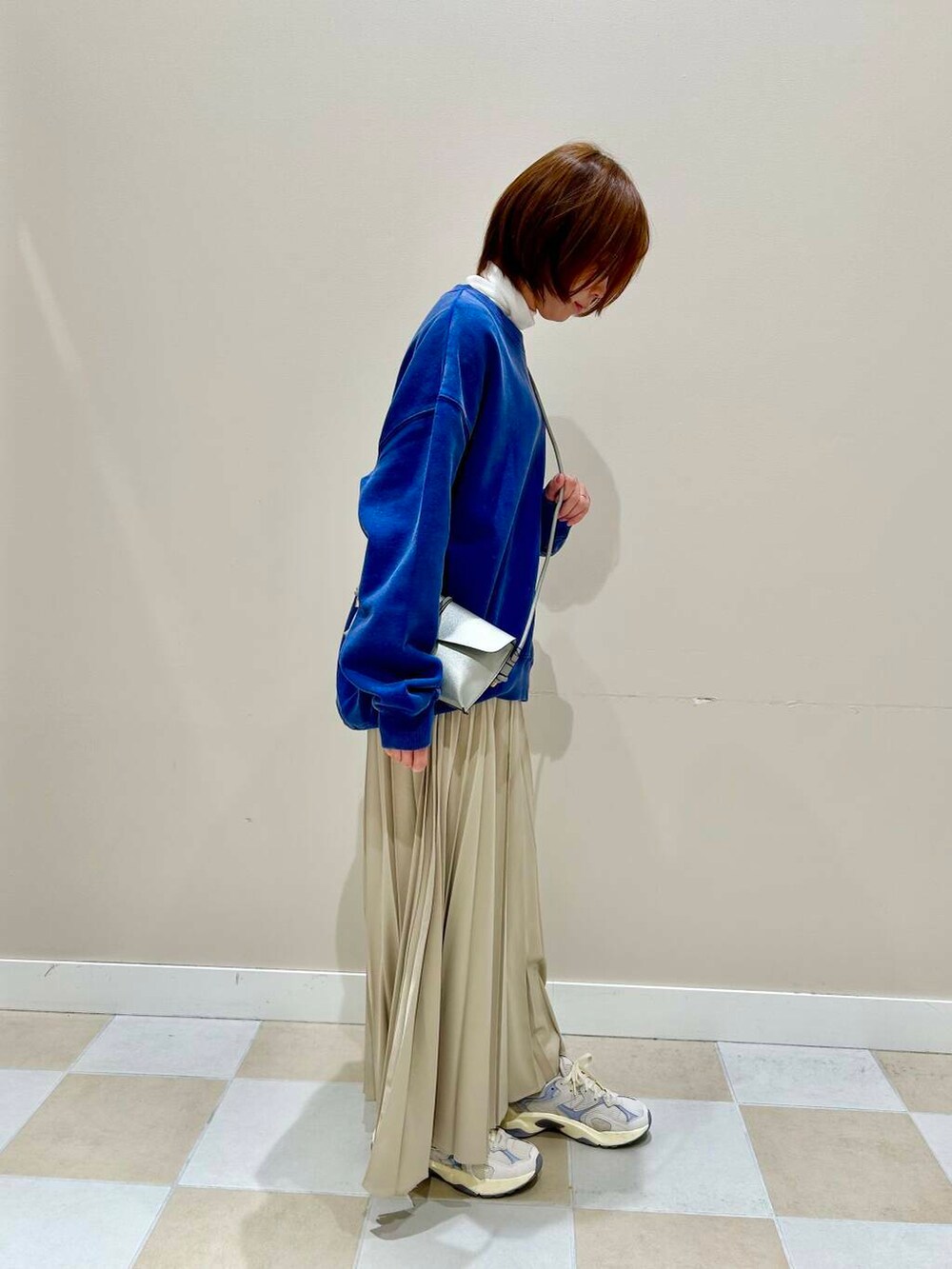 シルバー系のショルダーバッグ、ブルー系のTシャツ/カットソーを着用したレディースの冬コーディネートの2枚目の写真