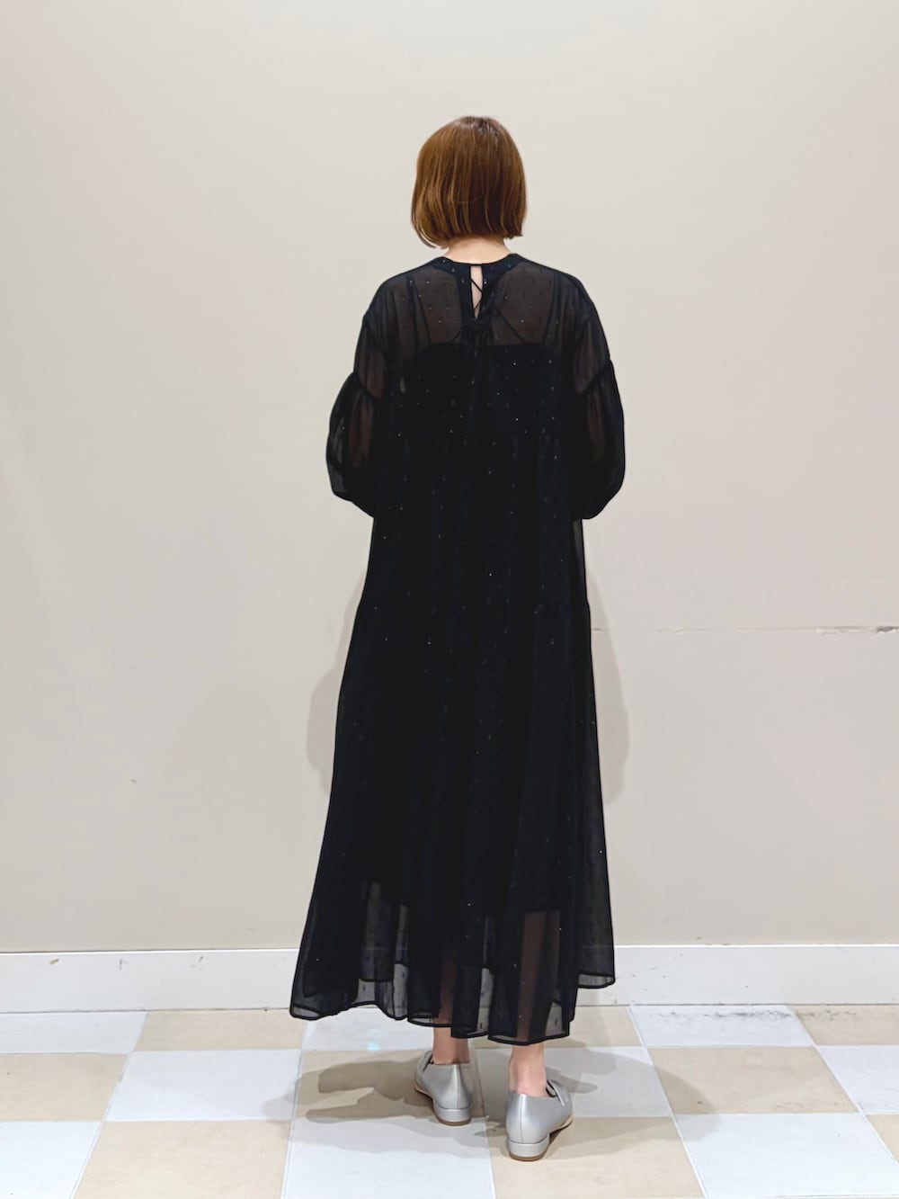 ブラック系のワンピース、シルバー系のハンドバッグを着用したレディースの冬コーディネートの3枚目の写真